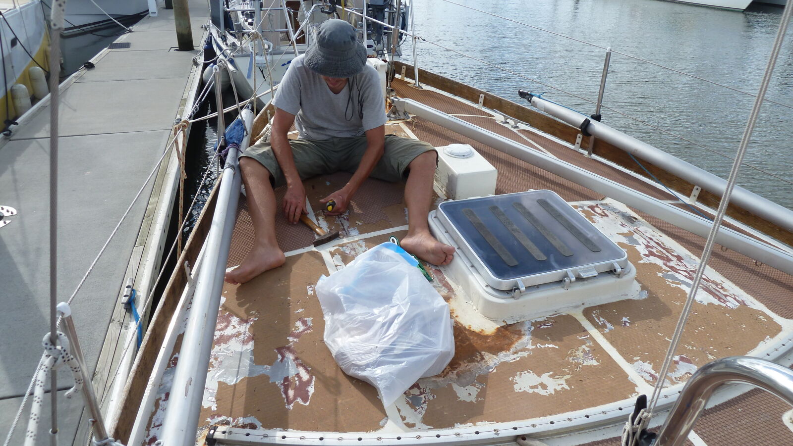 Noch im Wasser entfernen wir den Decksbelag und montieren nicht für die Überfahrt ins Trockendock benötigte Decksbeschläge ab.