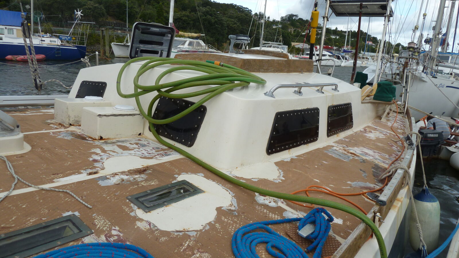 Noch im Wasser entfernen wir den Decksbelag und montieren nicht für die Überfahrt ins Trockendock benötigte Decksbeschläge ab.